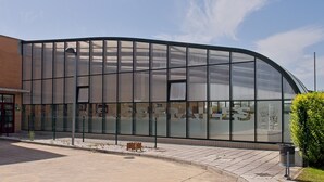 A modern building with large glass windows and a curved facade.