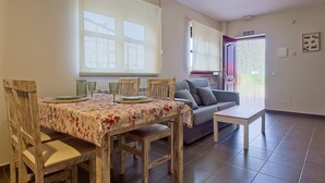 A dining area with a table set for four, a sofa, and a door marked 'SALIDA'.