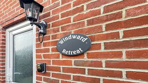 Un muro de ladrillo con un letrero que dice 'Windward Retreat'.