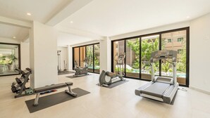 Ein geräumiges Fitnessstudio mit Laufbändern, Crosstrainern und Kurzhanteln.
