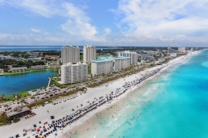 A coastal cityscape with a long beach, high-rise hotels, and a marina.