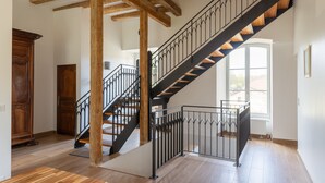 A staircase with wooden beams and black railings, leading to an upper floor. - Domaine 'Gîte De L'Abbaye' with Private Pool, Private Terrace and Wi-Fi (Rollainville)