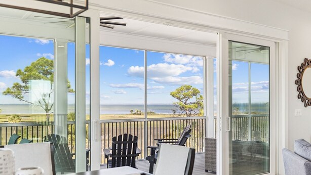 A balcony with a view of the ocean, a table, chairs, and a sofa. - 8 Minute Walk to Beach | Dogs Allowed (Port St. Joe)