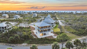 A coastal house with a large balcony, surrounded by natural vegetation and a view of the ocean. - 8 Minute Walk to Beach | Dogs Allowed (Port St. Joe)