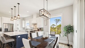 A modern kitchen with white cabinets, a central island, and pendant lighting. - 8 Minute Walk to Beach | Dogs Allowed (Port St. Joe)