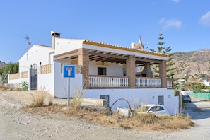 A two-story building with a balcony, a garage, and a clear sky. - Villa 'El Peli' with Sea View, Wi-Fi and Air Conditioning (Nerja)