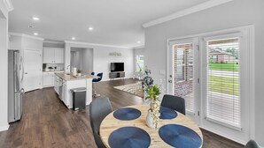 Una cucina moderna con zona pranzo, TV e vista sull'esterno.