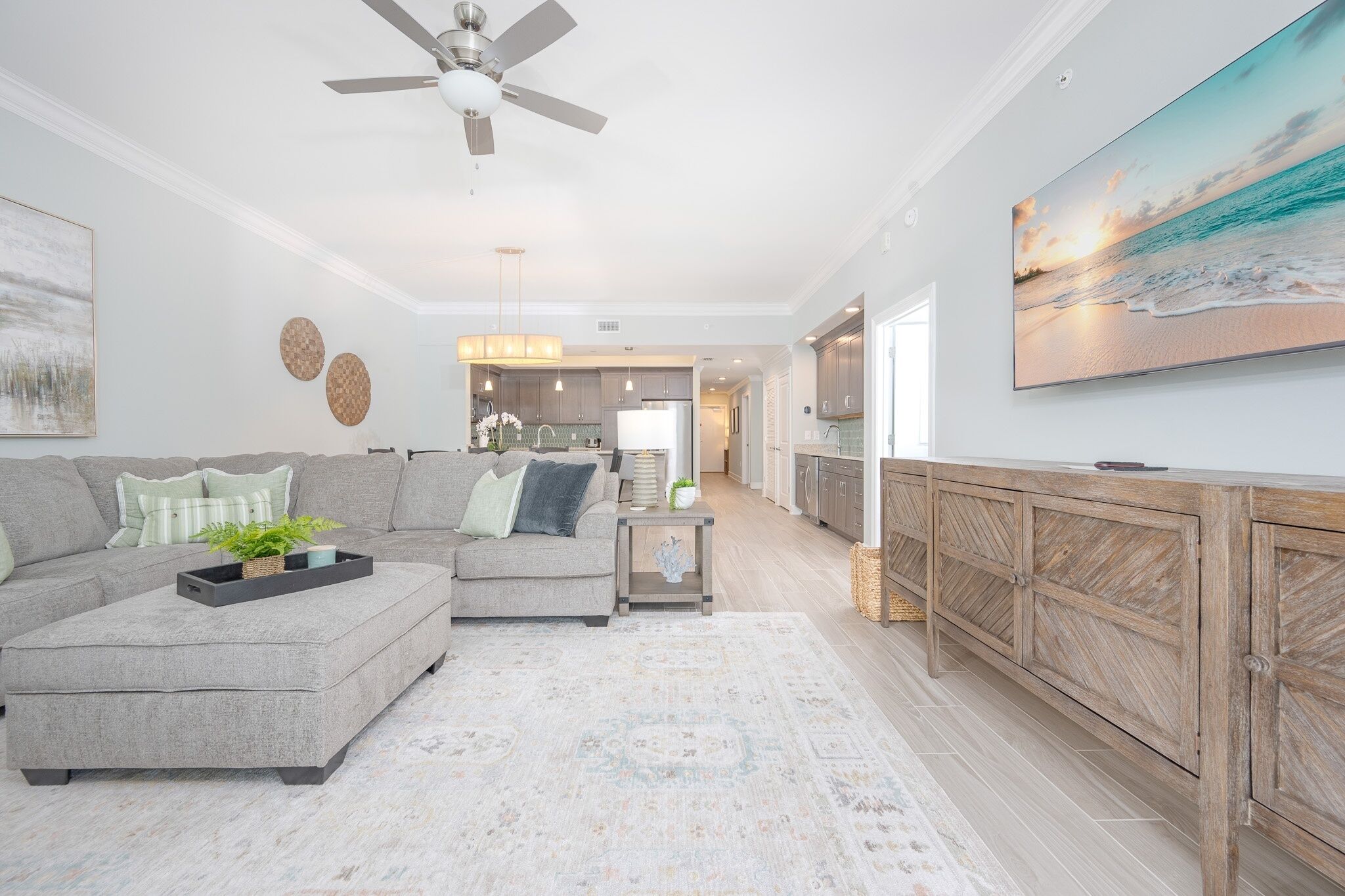 A modern living room with a grey sectional sofa, a coffee table, and a wooden cabinet.