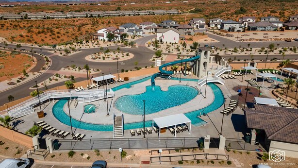 Un complexe hôtelier doté d’une piscine centrale, d’un toboggan aquatique et d’un parking.