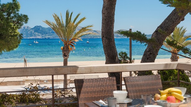 Una mesa con sillas y vista al mar.