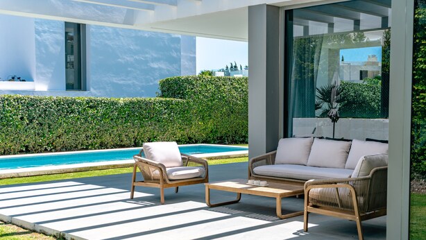 A modern outdoor seating area with wicker furniture and a pool in the background. - Villa 'Dominica' with Sea View, Wi-Fi and Air Conditioning (Estepona)