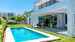 A modern house with a swimming pool, outdoor seating, and a covered patio. - Villa 'Dominica' with Sea View, Wi-Fi and Air Conditioning (Estepona)