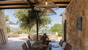 A covered outdoor dining area with a table set for four, surrounded by stone walls and a view of the landscape. - Palazzina Tommaso Sea View & Wellness "Adults Only" between Ostuni and Fasano (Fasano)
