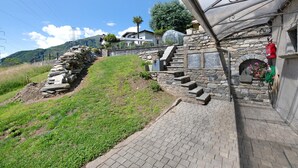 A stone staircase leading to a building with a stone fireplace and a metal awning. - Holiday Home 'Il Nido Del Colibrì' with Lake View, Private Terrace & Wi-Fi (Stazzona)