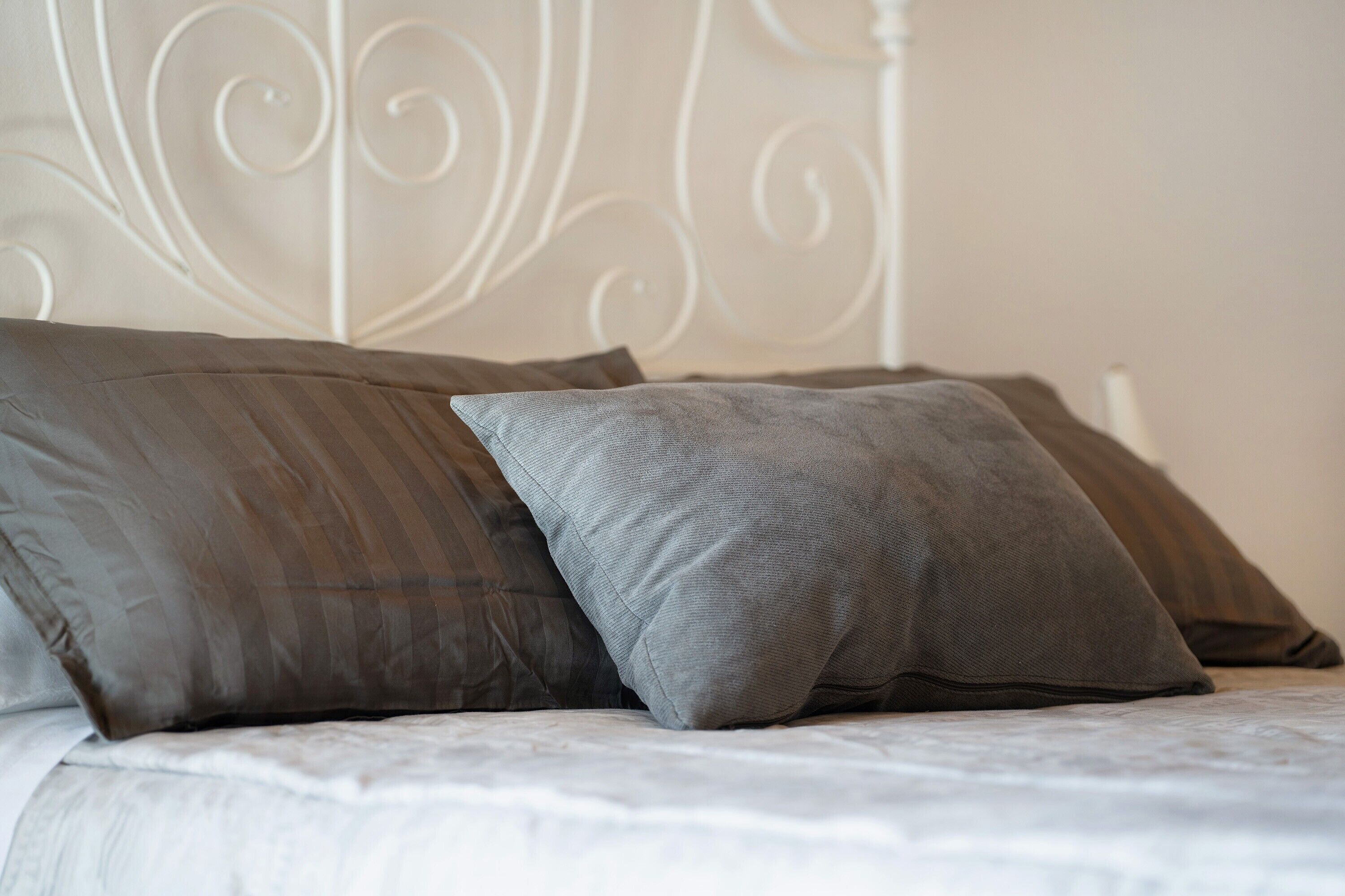 Ein Bett mit Kissen und einem weißen Kopfteil.