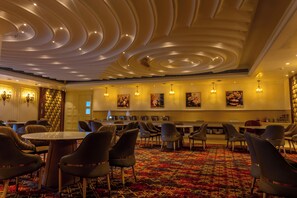 A hotel lobby with a patterned carpet, round tables, and modern chairs. - Maribella Hotel & Resort  (Amritsar)