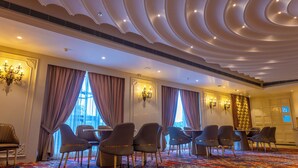A conference room with a patterned carpet, modern chairs, and a decorative ceiling. - Maribella Hotel & Resort  (Amritsar)