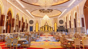 A grand hall with a central altar, ornate chandeliers, and rows of tables and chairs. - Maribella Hotel & Resort  (Amritsar)