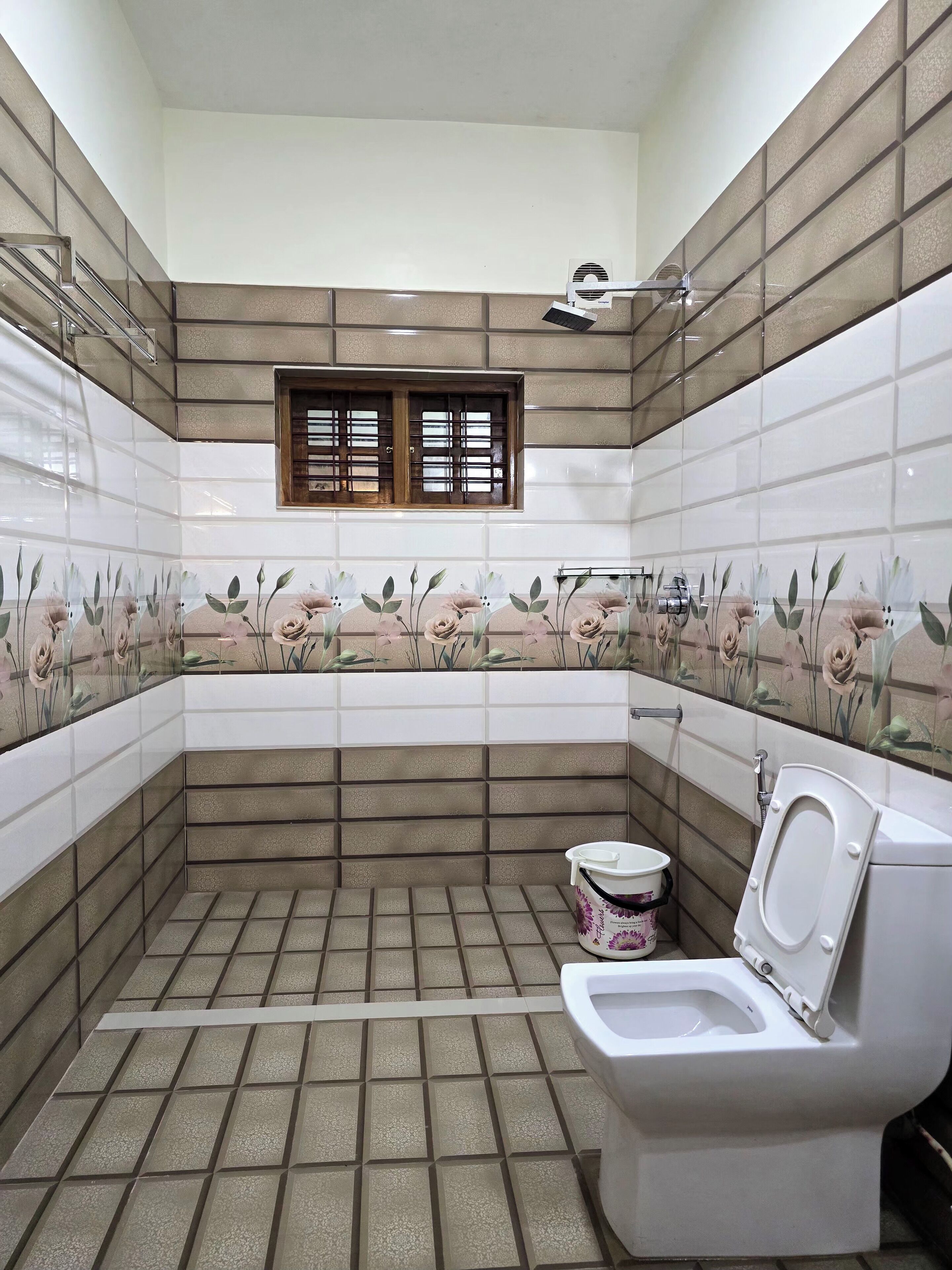 A bathroom with a toilet, a window, and tiled walls.
