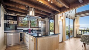 A modern kitchen with stainless steel appliances, wooden cabinets, and a large island. - 200m ski slopes-Chalet Manora -Courchevel La Tania (Courchevel)