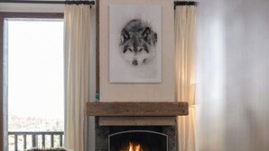 A cozy living room with a fireplace, a framed artwork above it, and a chair with a fur throw. - 200m ski slopes-Chalet Manora -Courchevel La Tania (Courchevel)