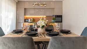 A dining table set with black plates, silverware, and wine glasses, centered with a vase of flowers. - Villa Cvita Zadar Villas (Privlaka)