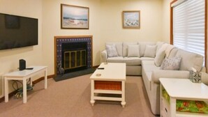A living room with a fireplace, a television, a sofa, and a coffee table.