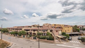 Zona residencial con casas adosadas, una calle con una señal de parada y cielo despejado.