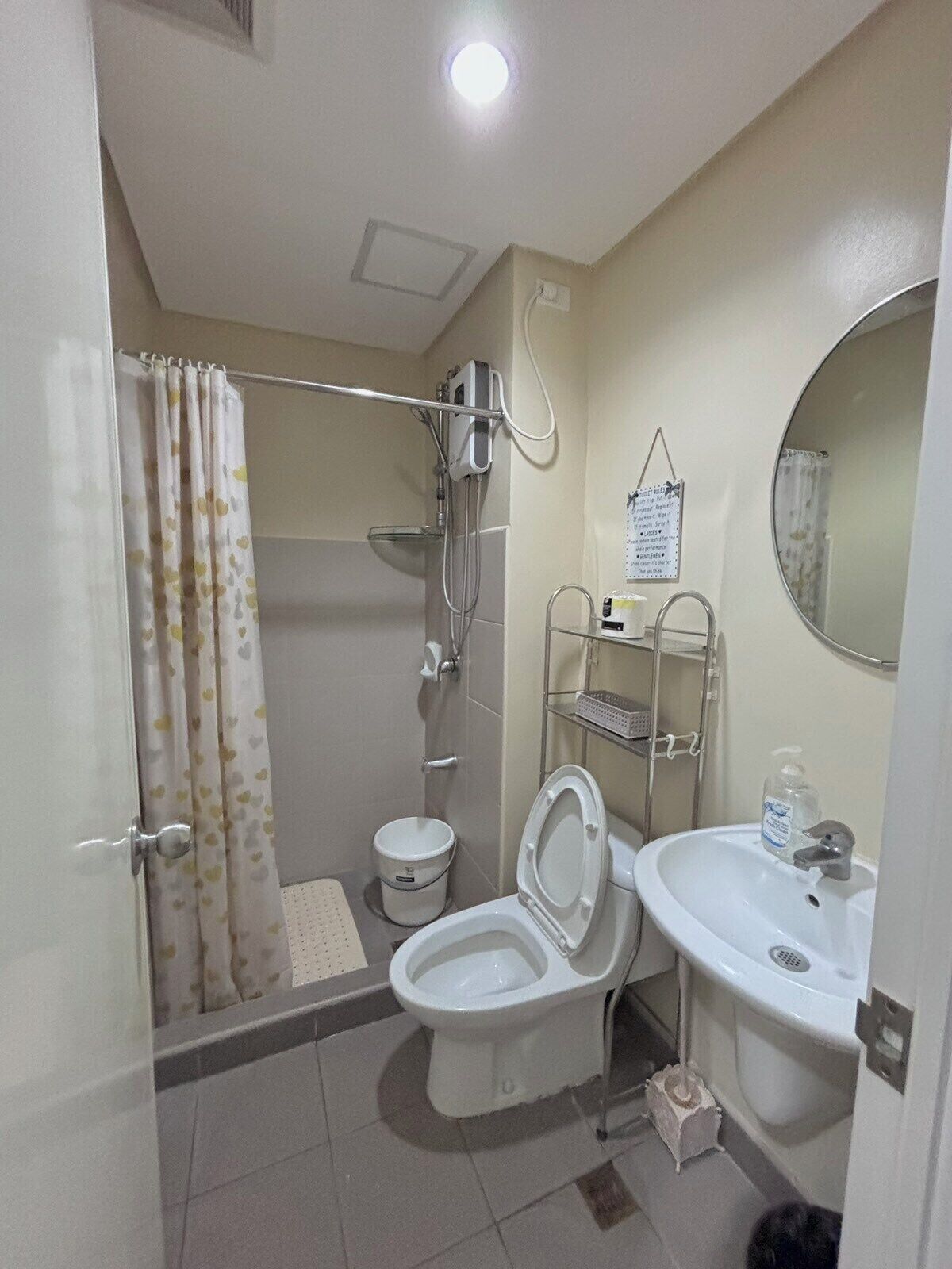 A bathroom with a shower, toilet, and sink.