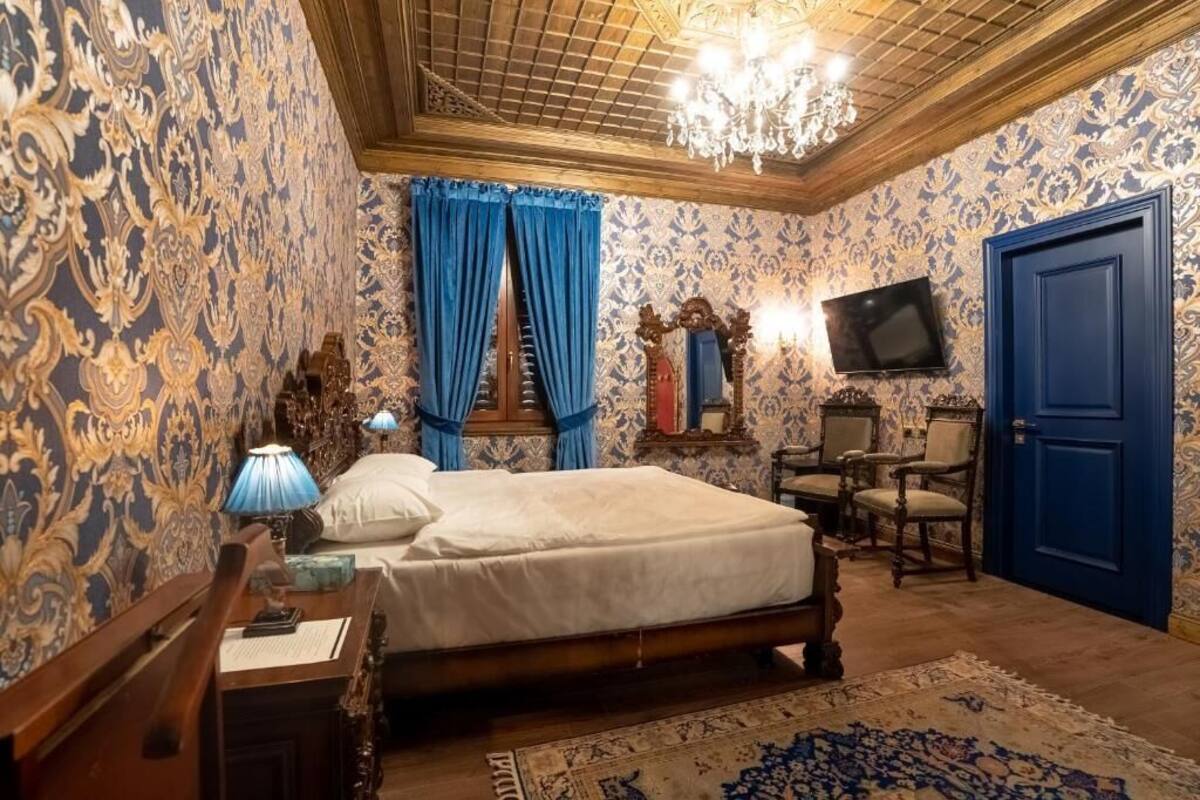 Une chambre à coucher avec un lit, un bureau, une chaise, un téléviseur et une porte.