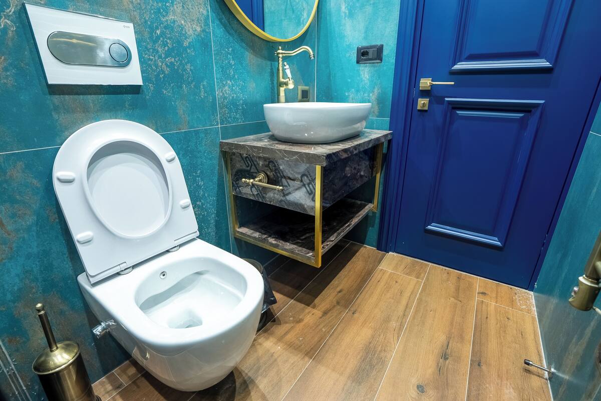 Une salle de bain avec des toilettes, un lavabo et une porte bleue.