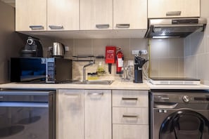 A modern kitchen with a microwave, kettle, sink, and a Samsung washing machine. - Cozy 2BR Getaway Minutes from Expo City, Dubai (Dubai)