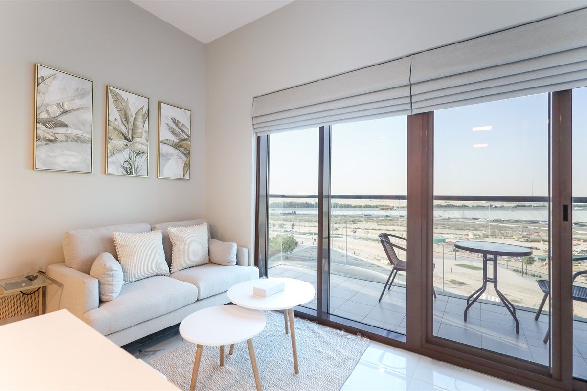 Una sala moderna con un sofá, una mesa de centro y un balcón con vistas.