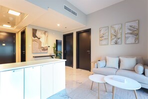 A modern living room with a sofa, two coffee tables, and artwork on the wall.