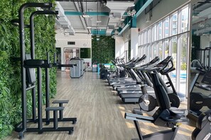 A gym with treadmills, weight machines, and a green wall. - Cozy 2BR Getaway Minutes from Expo City, Dubai (Dubai)