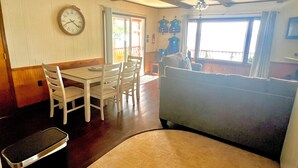 Un espace repas comprenant une table, des chaises, une horloge et un canapé.