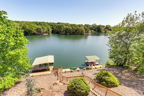 A lakeside property with a dock, a covered seating area, and a wooden deck. - Swim & Boat Docks: Lakefront Gem in Bella Vista! (Bella Vista)