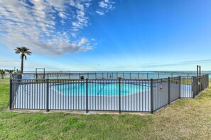 A fenced swimming pool with a clear view of the ocean. - Fish & Swim: Waterfront Rockport Condo w/ Views! (Rockport)
