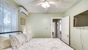 A bedroom with a bed, an air conditioning unit, a ceiling fan, and a door leading to another room. - 1 Mi to Ocala Dtwn Square: Home w/ Yard! (Ocala)
