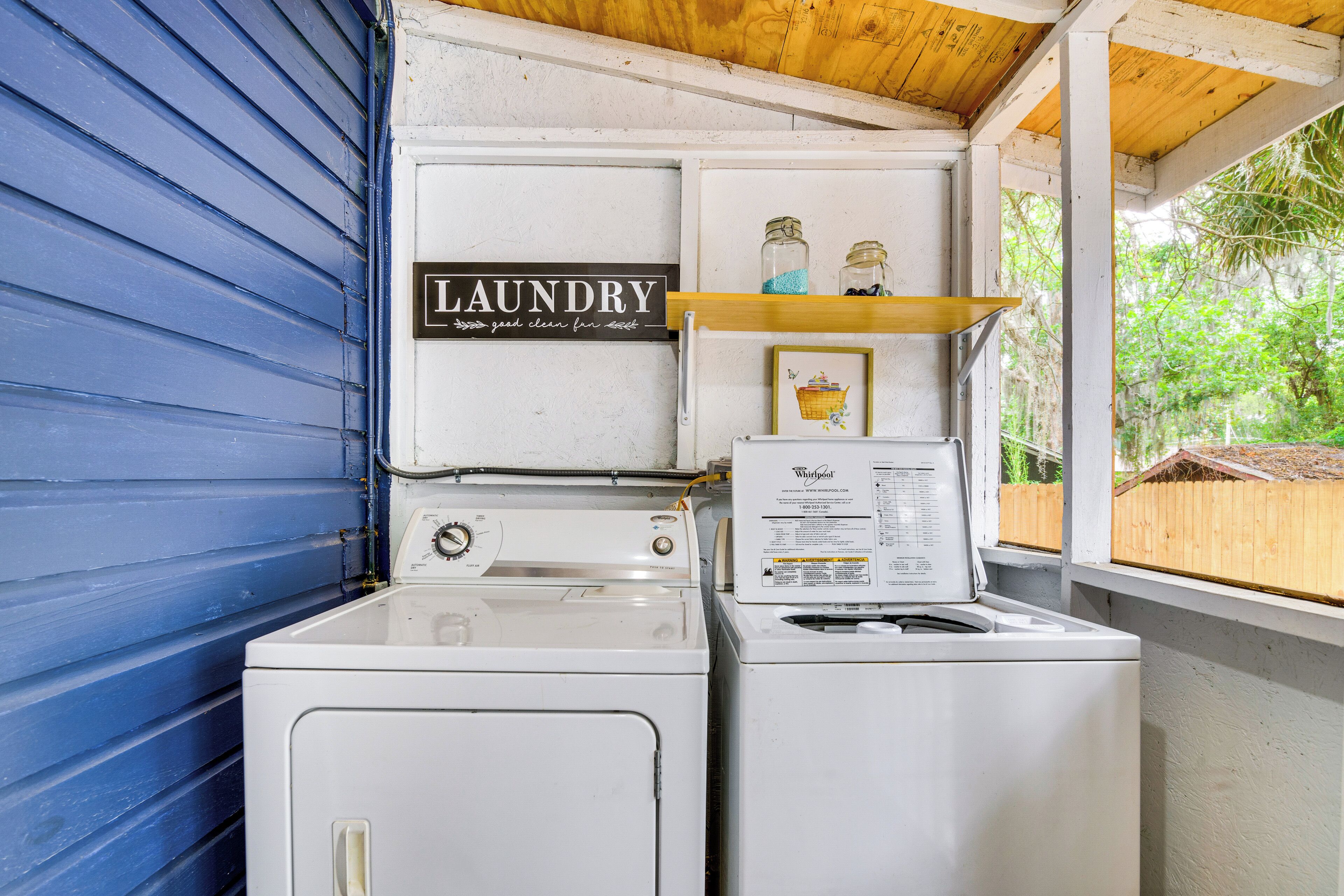 A laundry area with a sign reading "LAUNDRY" and a Whirlpool washer and dryer.