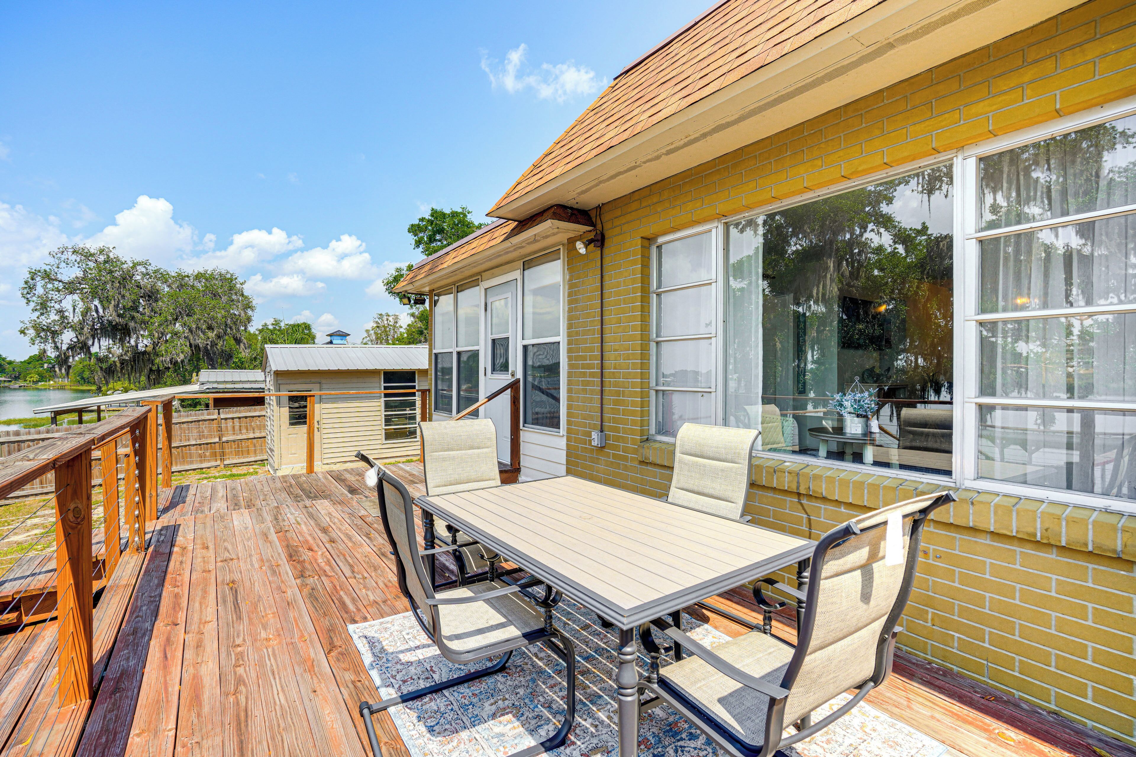A deck with a table and chairs, overlooking a body of water.