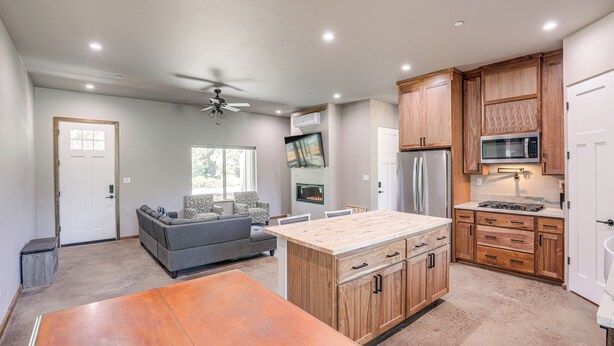 A modern kitchen with wooden cabinets, a central island, and built-in appliances. - 2 Mi to Lake Almanor: Home w/ Golf Course Views! (Westwood)