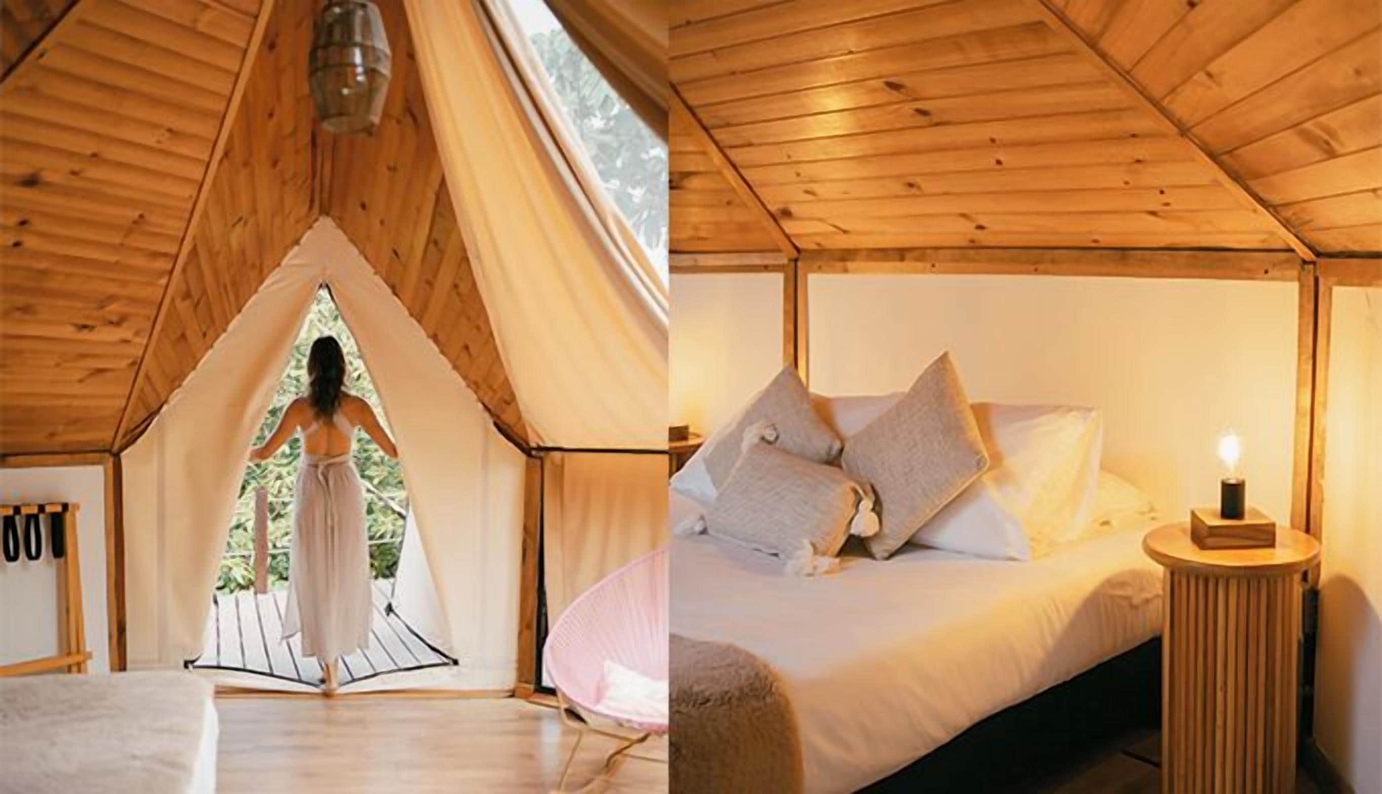 Una carpa con interior de madera, una cama con almohadas y una mesita de noche con una lámpara.