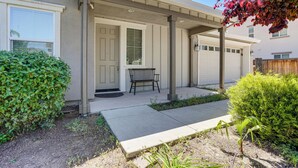 A residential building with a covered porch, a bench, and a small garden area. - Family Home w/ Patio & Fenced Yard in Brentwood (Brentwood)