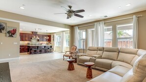 A spacious living room with a beige sofa, a wooden coffee table, and a ceiling fan. - Family Home w/ Patio & Fenced Yard in Brentwood (Brentwood)