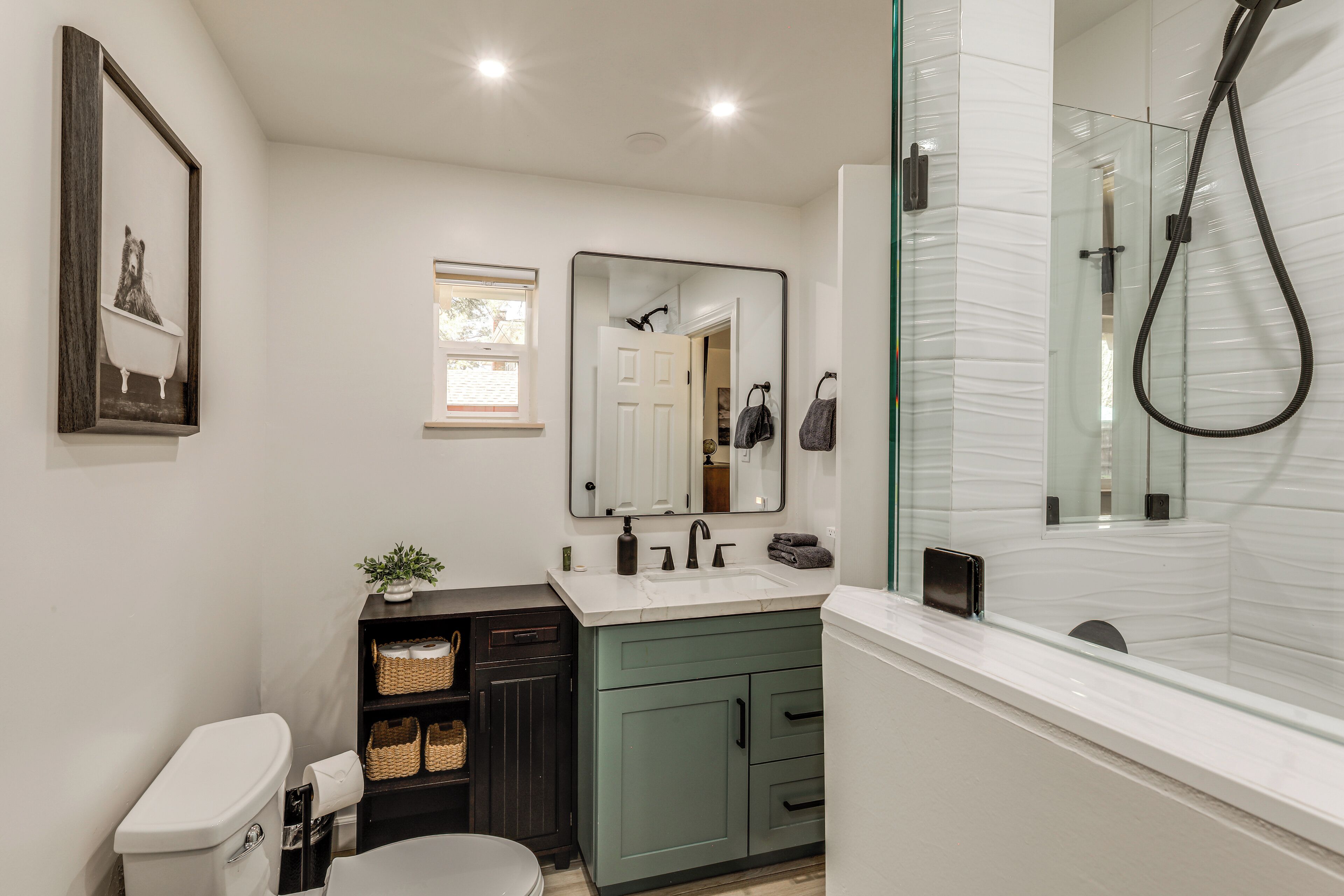 A modern bathroom with a toilet, sink, and shower.