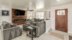 A modern living room with a fireplace, grey sofas, a coffee table, and a TV. - Walk to Dtwn Flagstaff: Home w/ Great Outdoor Area (Flagstaff)