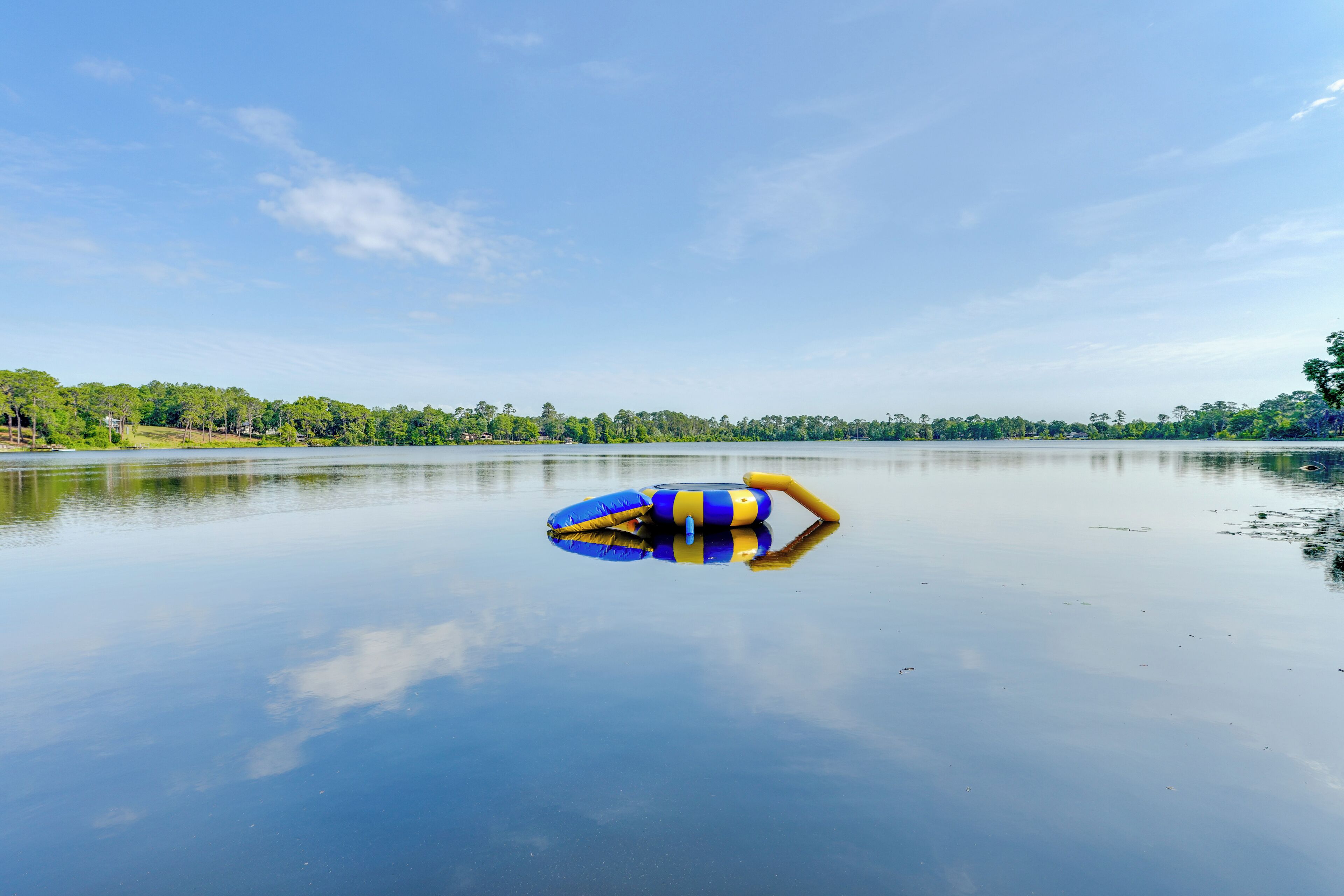 A calm lake with a blue and yellow inflatable raft floating on the water.