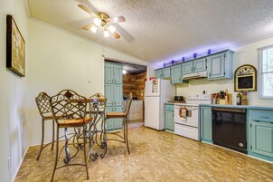 Una cocina con armarios azul claro, un refrigerador blanco, una estufa y un lavavajillas.