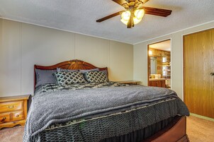 Un dormitorio con cama de madera, ventilador de techo y armario de madera.